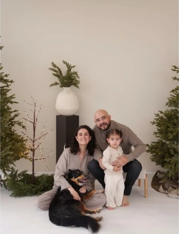 Papás, hija y perrito sentados en el set